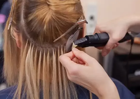 Individual strand being attached close to the root during a fitting
